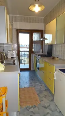 a large kitchen with yellow cabinets and a sink at Il Gabbiano al Capo in Palermo
