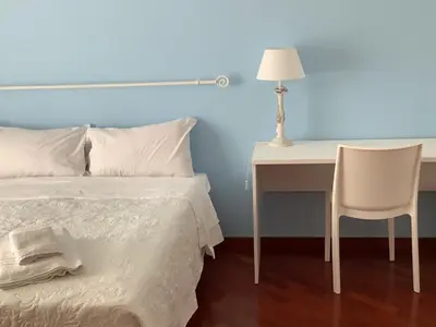 a bedroom with a bed and a desk and a chair at Leo's Home in Palermo