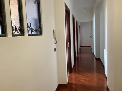 a hallway with white walls and a hard wood floor at Leo's Home in Palermo