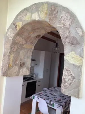 a kitchen with a table and a stone archway at Leo's Home in Palermo