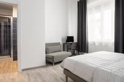a bedroom with a bed and a couch and a chair at Le Cinque Stanze Palermo Room&Breakfast in Palermo