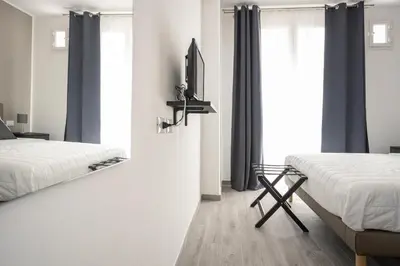a bedroom with two beds and a tv on a wall at Le Cinque Stanze Palermo Room&Breakfast in Palermo