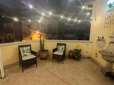 a balcony with two chairs and a sink and lights at In Piazza casavacanze in Palermo