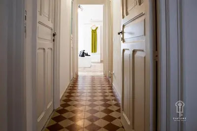 a hallway with a checkered floor and two doors at Ciatu mè in Alcamo