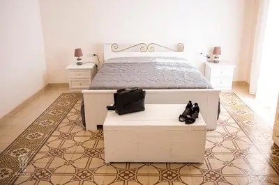 a bedroom with a white bed and two night stands at Ciatu mè in Alcamo