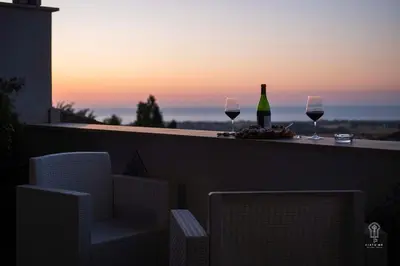 two glasses of wine and a bottle on a balcony at Ciatu mè in Alcamo
