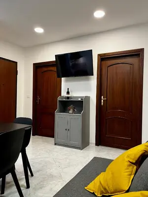 a living room with a tv and two wooden doors at Mondello front beach in Palermo