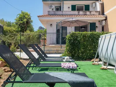 a patio with two lawn chairs and an umbrella at Holiday Home Alice by Interhome in Ficarazzi