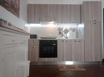 a kitchen with wooden cabinets and a black oven at Al Molo 6 in Palermo