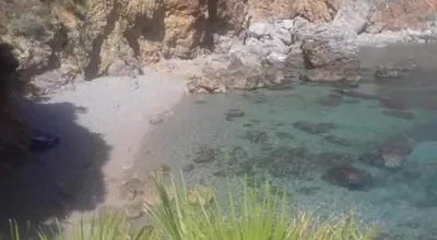 a body of water next to a rocky shore at B&B Poliglotta in Castelluzzo