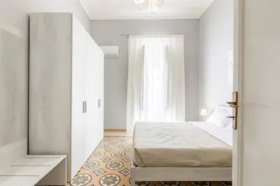 a white bedroom with a bed and a window at GuestHost - Stazione Notarbartolo Bright & Cozy Apartment in Palermo