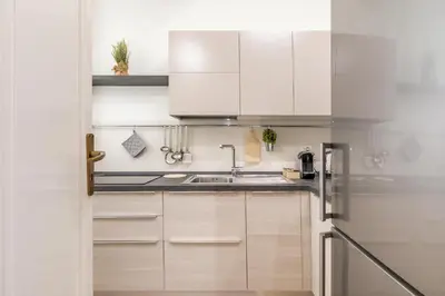 a kitchen with white cabinets and a sink at GuestHost - Stazione Notarbartolo Bright & Cozy Apartment in Palermo