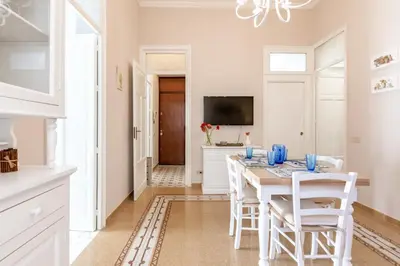 a white kitchen with a dining room table and chairs at GuestHost - Stazione Notarbartolo Bright & Cozy Apartment in Palermo