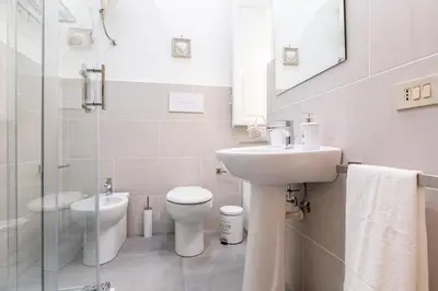 a white bathroom with a sink and a toilet at GuestHost - Stazione Notarbartolo Bright & Cozy Apartment in Palermo