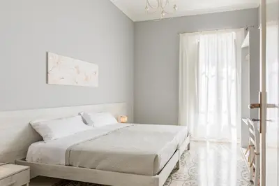 a white bedroom with a bed and a window at GuestHost - Stazione Notarbartolo Bright & Cozy Apartment in Palermo