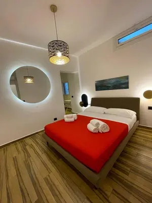 a bedroom with a bed with a red blanket at BB4U Apartments al Massimo in Palermo