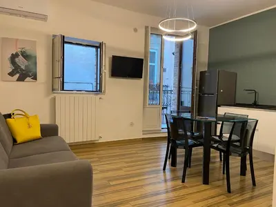 a living room with a table and chairs and a kitchen at BB4U Apartments al Massimo in Palermo