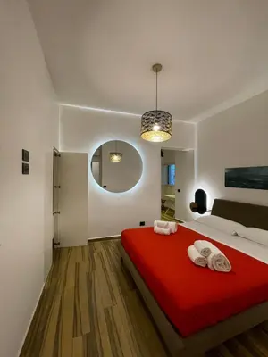 a bedroom with a red bed with towels on it at BB4U Apartments al Massimo in Palermo