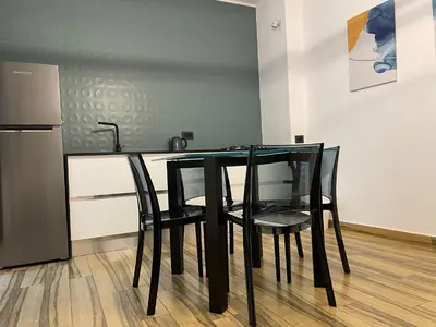a black table with black chairs in a kitchen at BB4U Apartments al Massimo in Palermo