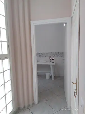 a white bathroom with a sink and a table at Sea life Terrasini in Terrasini