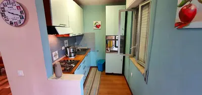 a kitchen with blue and green walls and a clock at Charming house with sea and mountain views in Alcamo in Alcamo