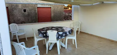 a table and chairs on a patio with a table at Charming house with sea and mountain views in Alcamo in Alcamo