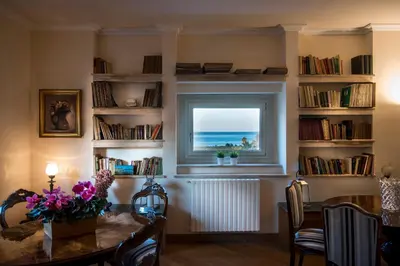 a dining room with a table and a window with the ocean at Residence Torremuzza - Charming House In The Heart Of Palermo with lovely view in Palermo