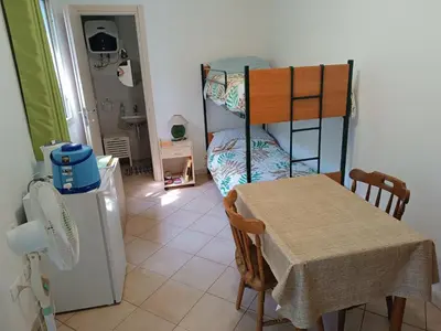 a room with a table and a bunk bed at Camera indipendente con bagno immersa nel verde in Bagheria