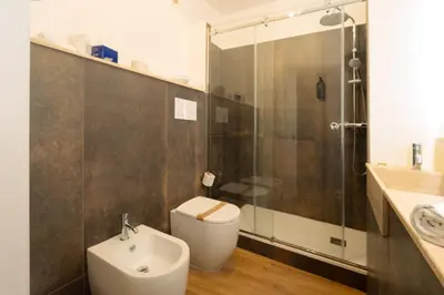 a bathroom with a toilet and a shower and a sink at Hotel Bel 3 in Palermo