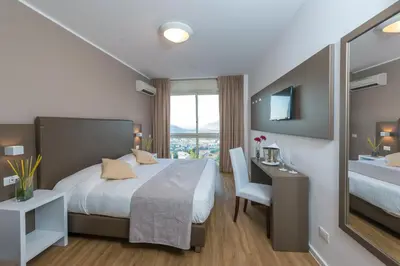 a hotel room with a bed and a desk and a window at Hotel Bel 3 in Palermo