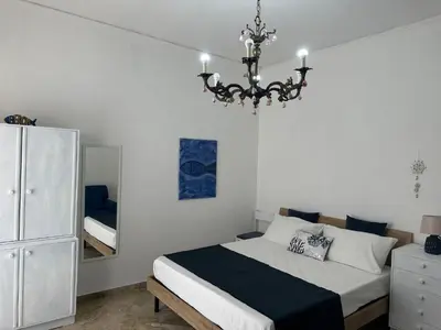 a bedroom with a bed and a chandelier at Le stanze di Anna in Capaci