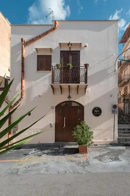 a white building with a balcony and a door at Bed and Breakfast Nilu' in Castellammare del Golfo