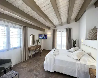 a bedroom with a large white bed and a desk at L'Ulivo Comfort Rooms in Terrasini