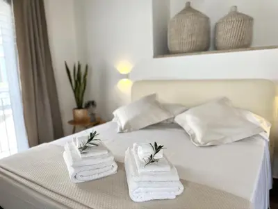 a white bed with towels on top of it at L'Ulivo Comfort Rooms in Terrasini