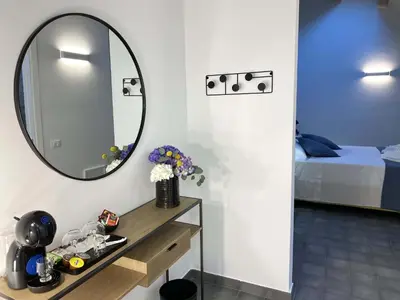 a room with a mirror and a table and a bed at L'Ulivo Comfort Rooms in Terrasini
