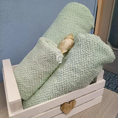 a green pillow in a wooden box with a heart at La casetta della Letizia in Mondello