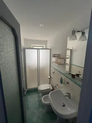 a bathroom with two toilets and a sink and a mirror at La casetta della Letizia in Mondello