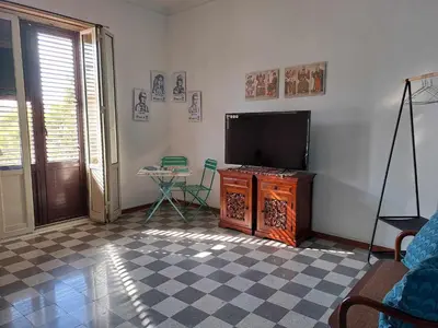 a living room with a flat screen tv and a table at La casa sull'albero in Palermo