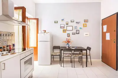 a kitchen with a table and chairs and a refrigerator at La Boucherie in Palermo