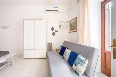 a living room with a gray couch with blue pillows at La Boucherie in Palermo