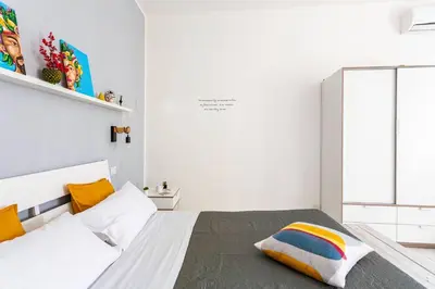 a white bedroom with a bed and a window at La Boucherie in Palermo