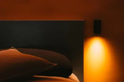 a bed with a light next to a pillow and a lamp at MONTESANTO36 APARTMENTS in Palermo