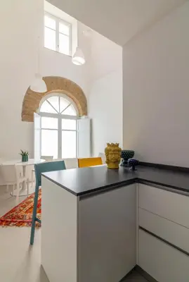 a kitchen with a black counter top in a room at La casetta in centro storico: Pantelleria 9 in Palermo