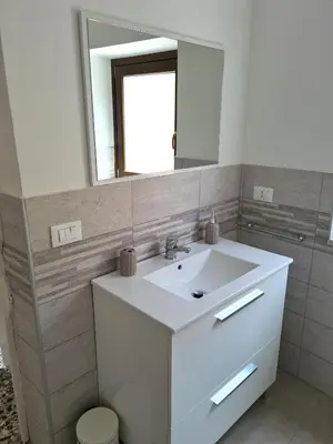 a bathroom with a white sink and a mirror at Casa Lara in Castellammare del Golfo