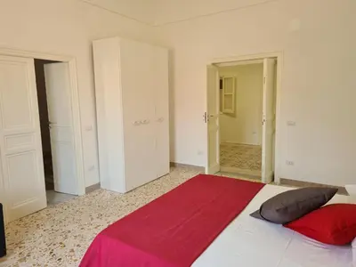 a bedroom with a large bed with a red blanket at Casa Lara in Castellammare del Golfo