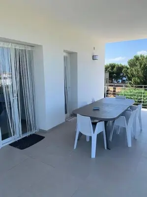 a table and chairs in a room with a balcony at Villa Bouganville - charming sea ​​view- 160 mq in Alcamo