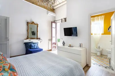 a living room with a table and a chair at Binario 91 Rooms in Palermo