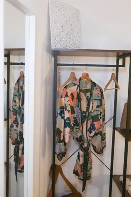 two shirts on a rack in a closet at Sole Apartment in Palermo