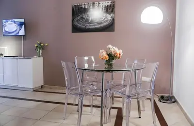 a dining room table with chairs and a vase of flowers at Sole Apartment in Palermo