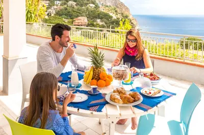a man and woman sitting at a table with food at La Villa di Sofia in Santa Flavia